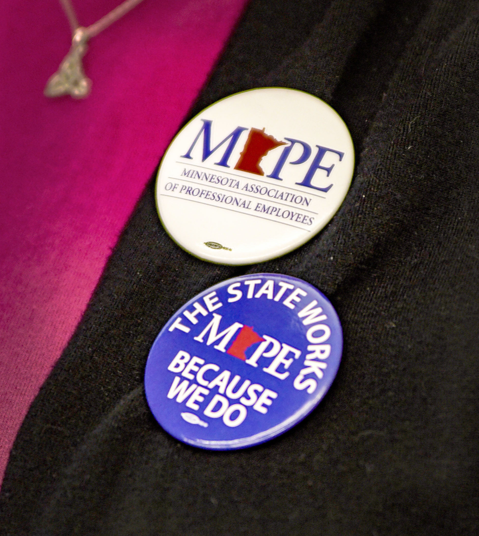 An audience member wears a pair of Minnesota Association of Professional Employees buttons to show solidarity during the Oct. 5 meeting of the LCC Subcommittee on Employee Relations. The subcommittee rejected a pair of collective bargaining agreements. Photo by Andrew VonBank